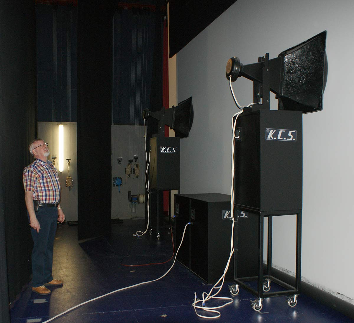 Steen Rasmussen viser frem to av de tre frontkanalene. Kinolerretet er akustisk transparent, så de enorme høyttalerne kan plasseres korrekt i forhold til bildet. 