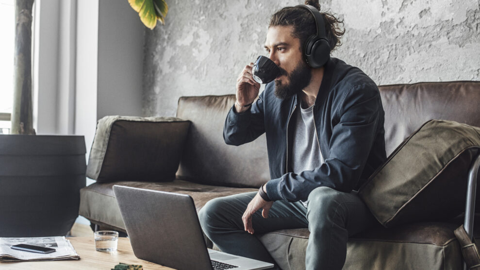 Handsome modern Caucasian man with beard drinking coffee.