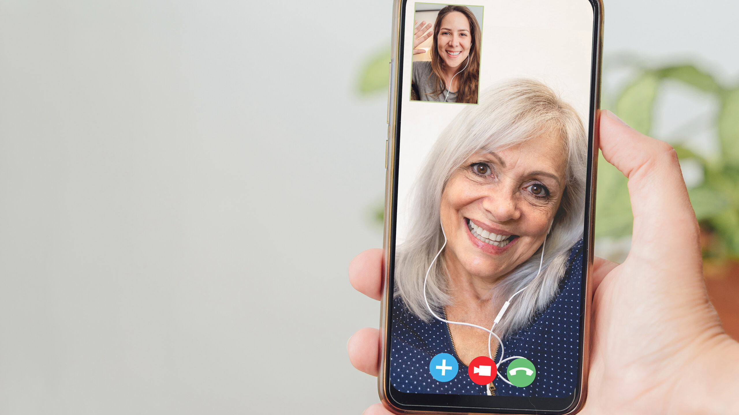 15-årsgrense for sosiale medier: Er det allerede for sent? 3 Happy senior and daughter talking on video call with mobile phone - Focus on hand holding smartphone