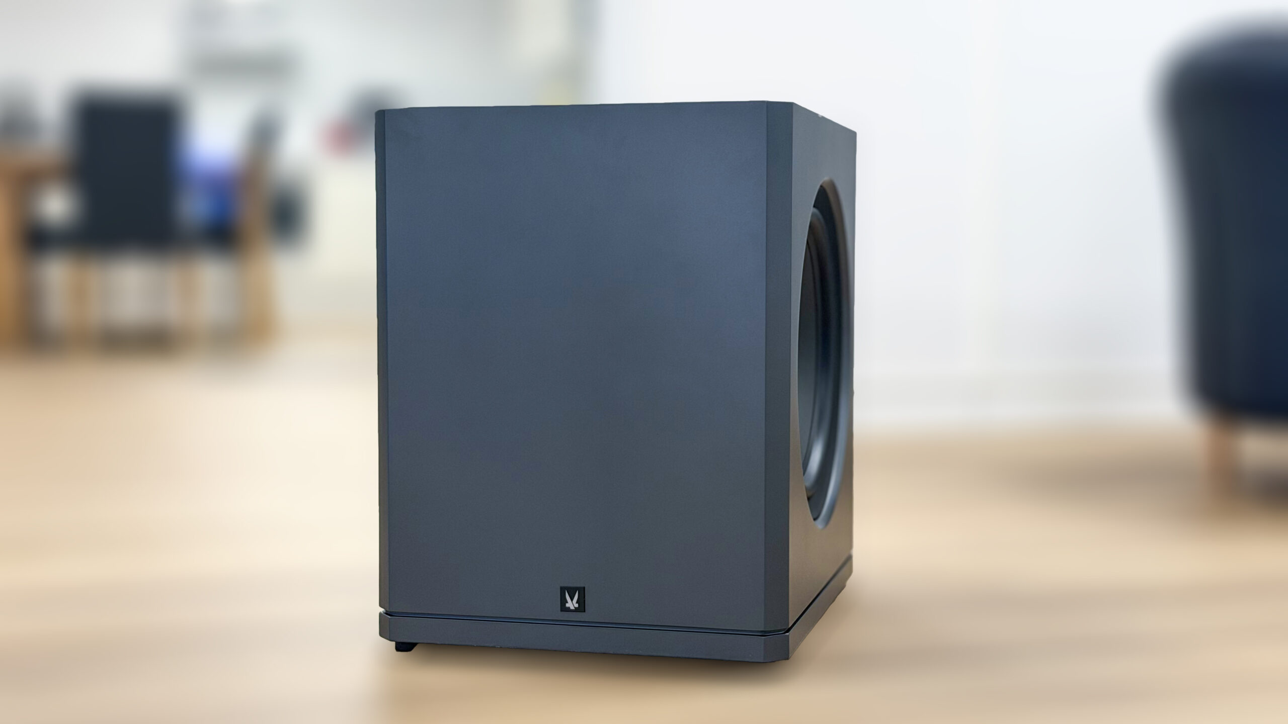 Arendal Sound 1723 Subwoofer 2S i mørk grå, stående på et tregulv. Lukket, kubeformet kabinett med ett synlig basselement på siden og Arendal-logo nederst på fronten.