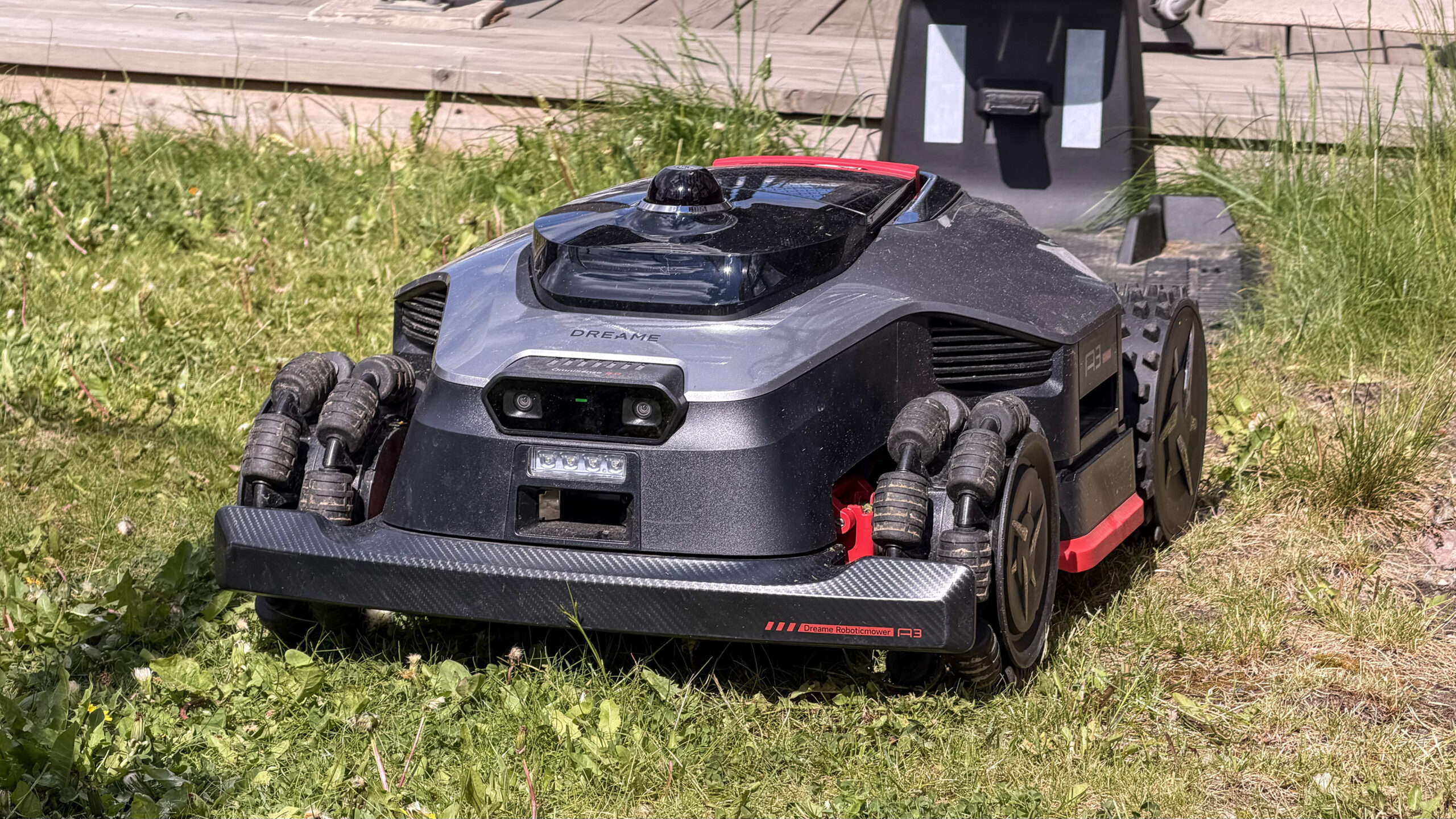 Frontvinkel av Dreame A3 AWD Pro, der man tydelig ser det doble AI-kameraet, LED-frontlysene, gummibumperen i karbonlook og de tett-stilte rullehjulene foran.