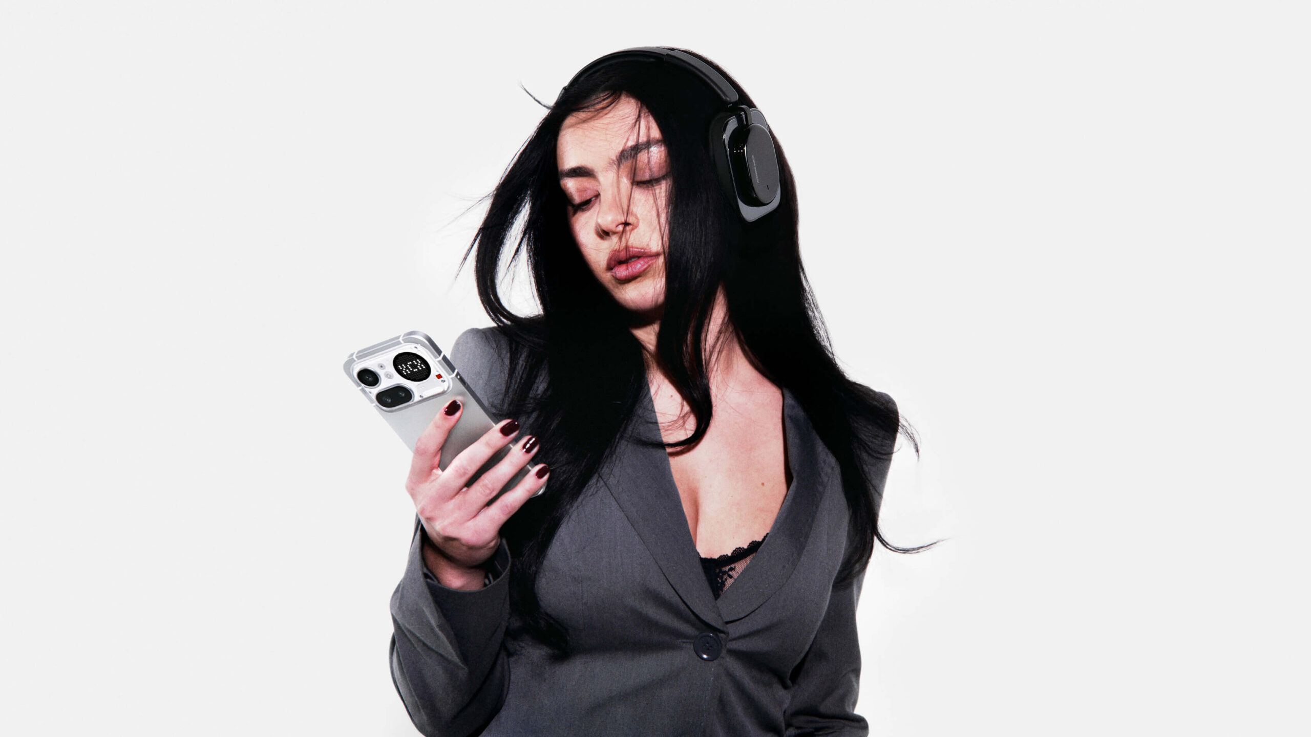 Nothing Headphone (a) 6 Kvinne med hvite Nothing Headphone (a) som holder en mobiltelefon