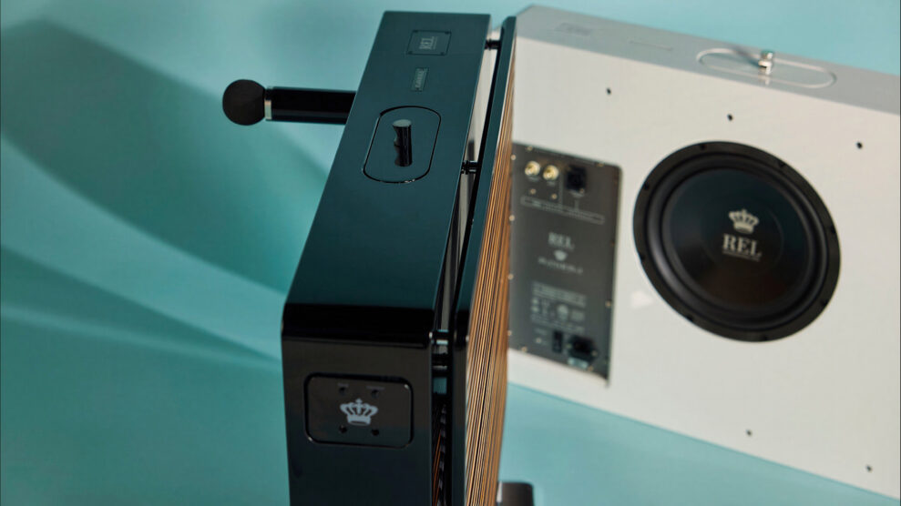 Nærbilde av REL Planar-subwoofer som viser den 14,5 cm tynne sideprofilen, transporthåndtaket på toppen og 10-tommers passiv radiator i hvitt kabinett bak.