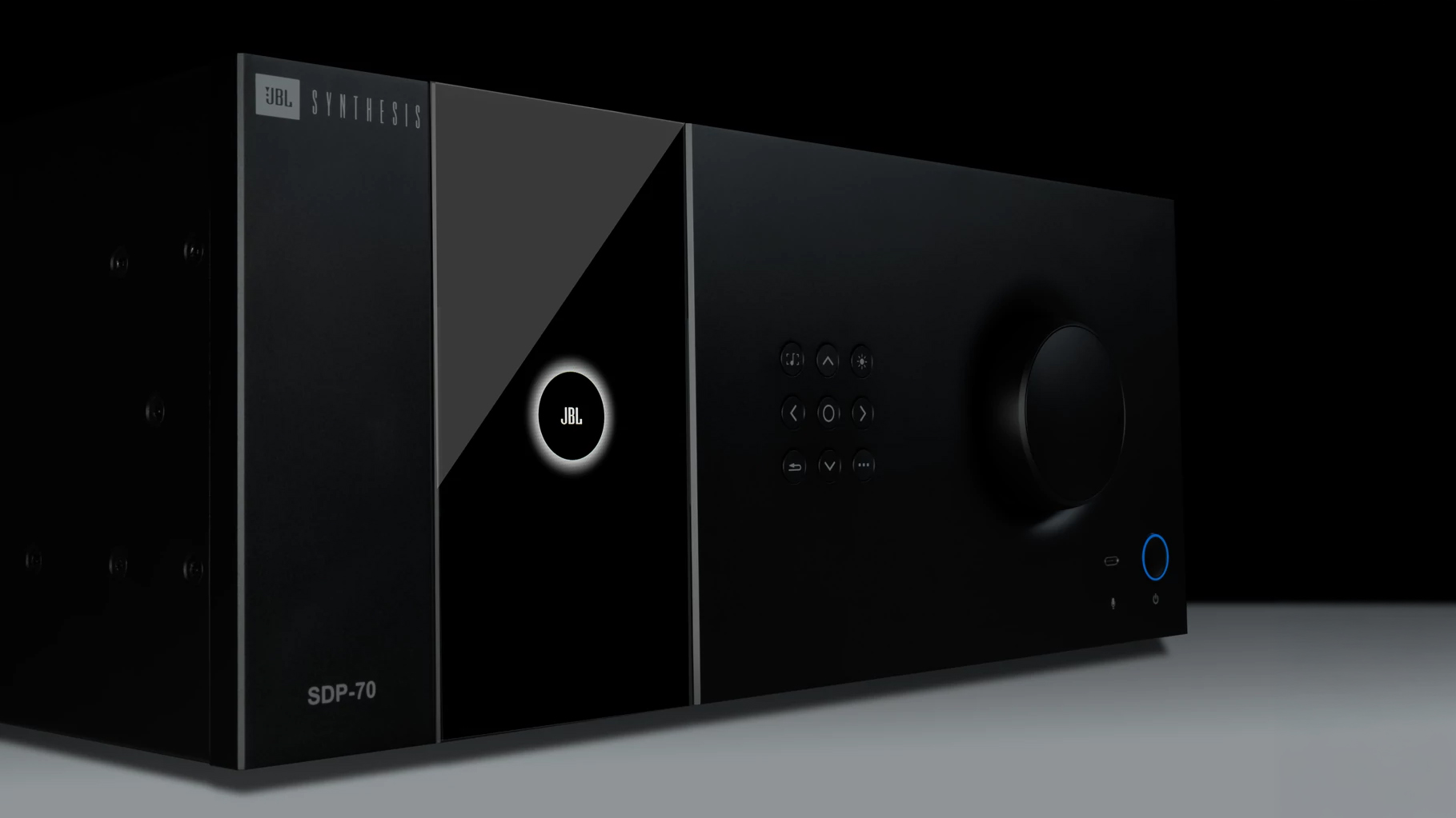 Ny JBL Synthesis: kraften du ikke ser 2 Sort JBL Synthesis SDP-70 prosessor fotografert på skrå mot lys bakgrunn. Blank front med JBL-logo i en opplyst ring, en rad med kontrollknapper og et stort dreiehjul til høyre. Modellnavnet SDP-70 står nederst til venstre.