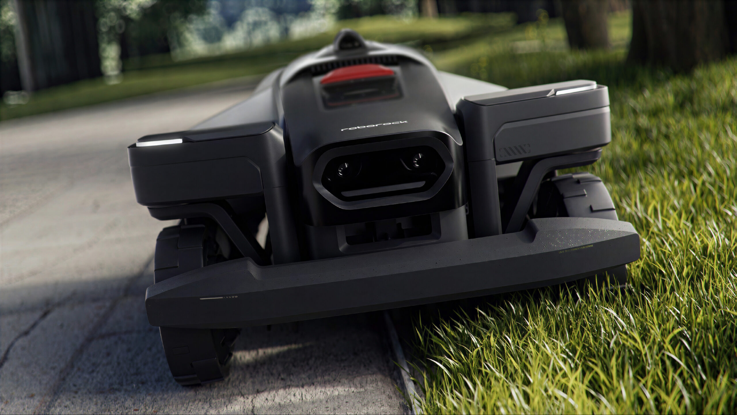 Roborock RockMow Z120 LiDAR 6 Roborock RockMow Z120 sett forfra med de to frontkameraene synlige, i kanten mellom vei og gress.