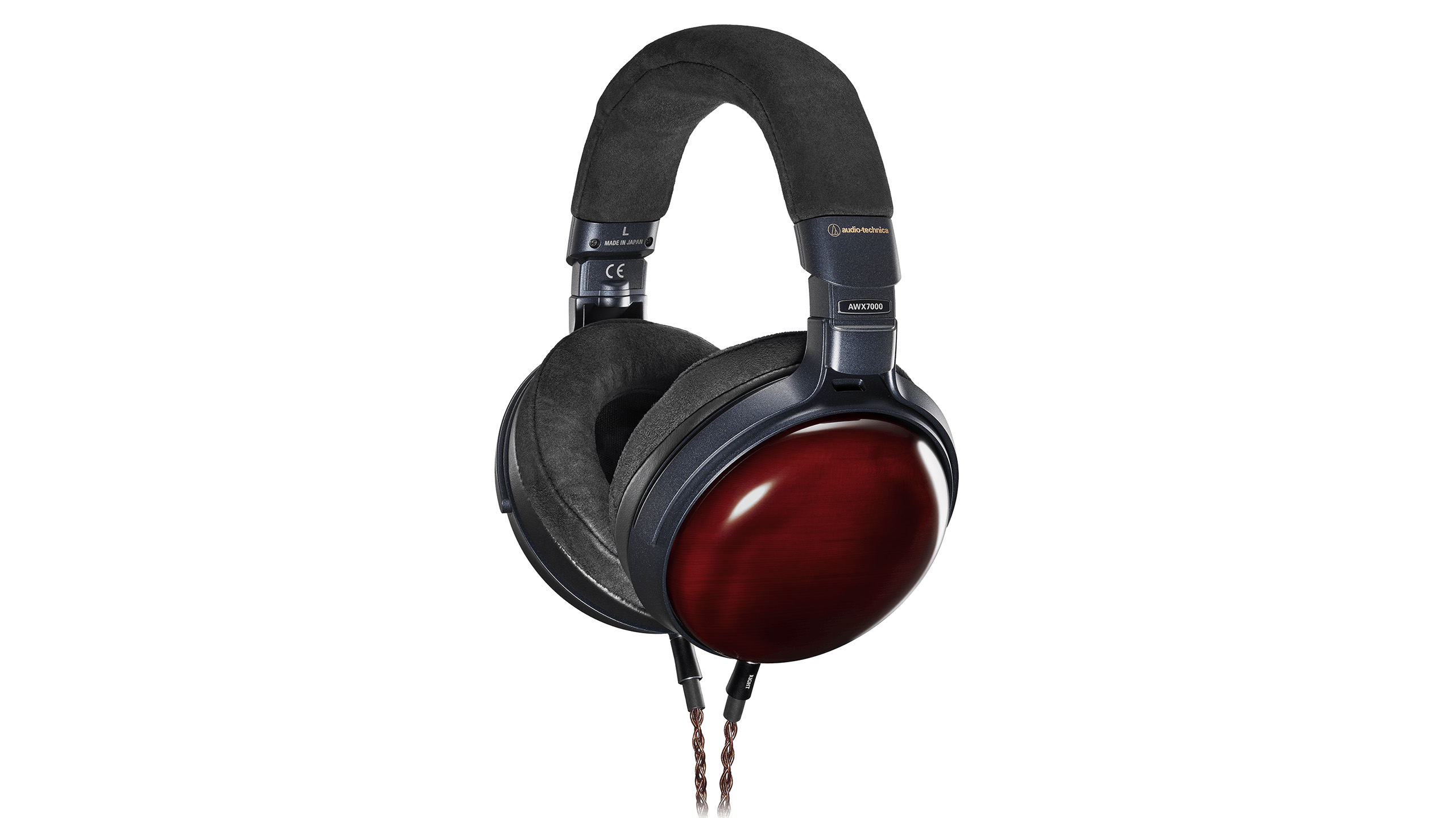 Audio-Technica lover åpen drømmelyd fra de lukkede ATH-AWX7000 1 Audio-Technica ATH-AWX7000 med mørkerøde øreklokker i lakkert tre, sorte øreputer og flettet kabel, sett skrått forfra.
