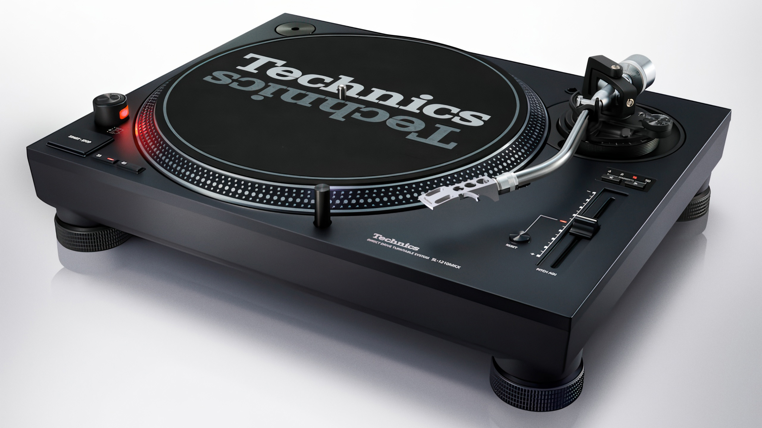 Technics SL-1210MKX: Tung DJ-platespiller med presis pitch 2 Technics SL-1210MKX sett skrått forfra, med svart kabinett og fire isolasjonsføtter.